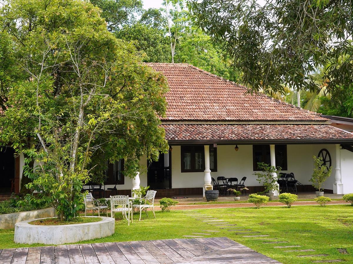 Villa with a tiled roof and open veranda set in a garden, photographed from ground level